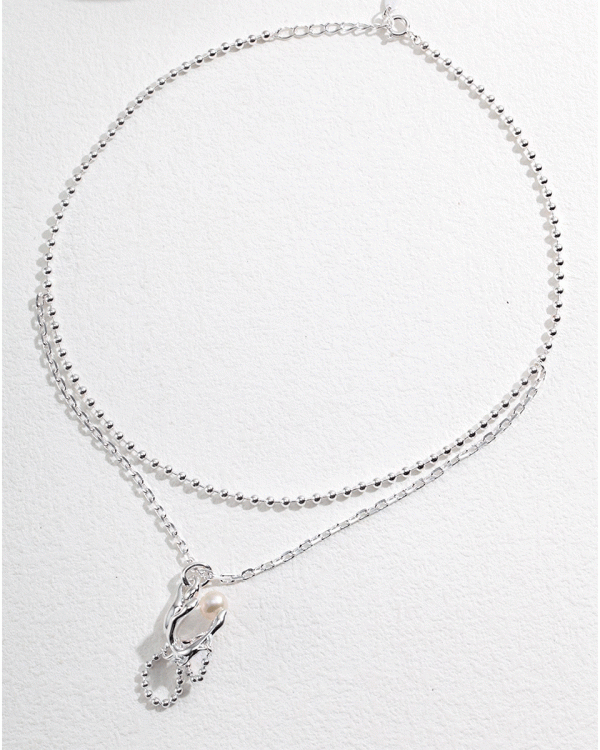 a Sterling silver double chain necklace with a pearl pendant